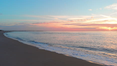 Una-Marea-Baja-Tranquila-En-La-Playa-Cerca-De-La-Barrera-De-Marejada-En-El-Suroeste-De-Los-Países-Bajos,-Durante-La-Puesta-De-Sol