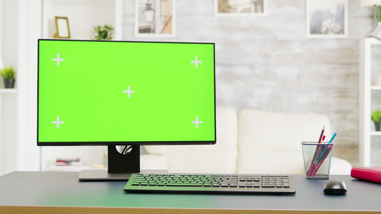 Office setup with a computer featuring a green screen