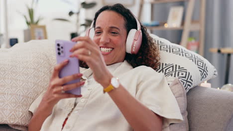woman relaxing on couch with headphones and phone
