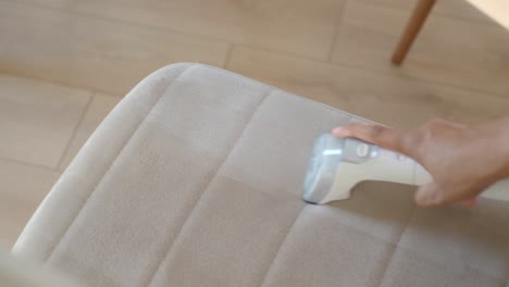 limpiando una silla con un limpiador de vapor