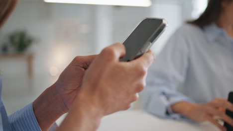 las manos de la mujer desplazando la pantalla en el trabajo de primer plano. el gerente de la oficina desliza el teléfono móvil