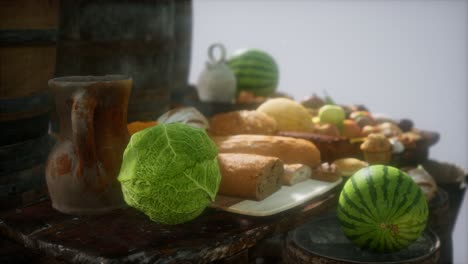 mesa de comida con barriles de vino y algunas frutas, verduras y pan