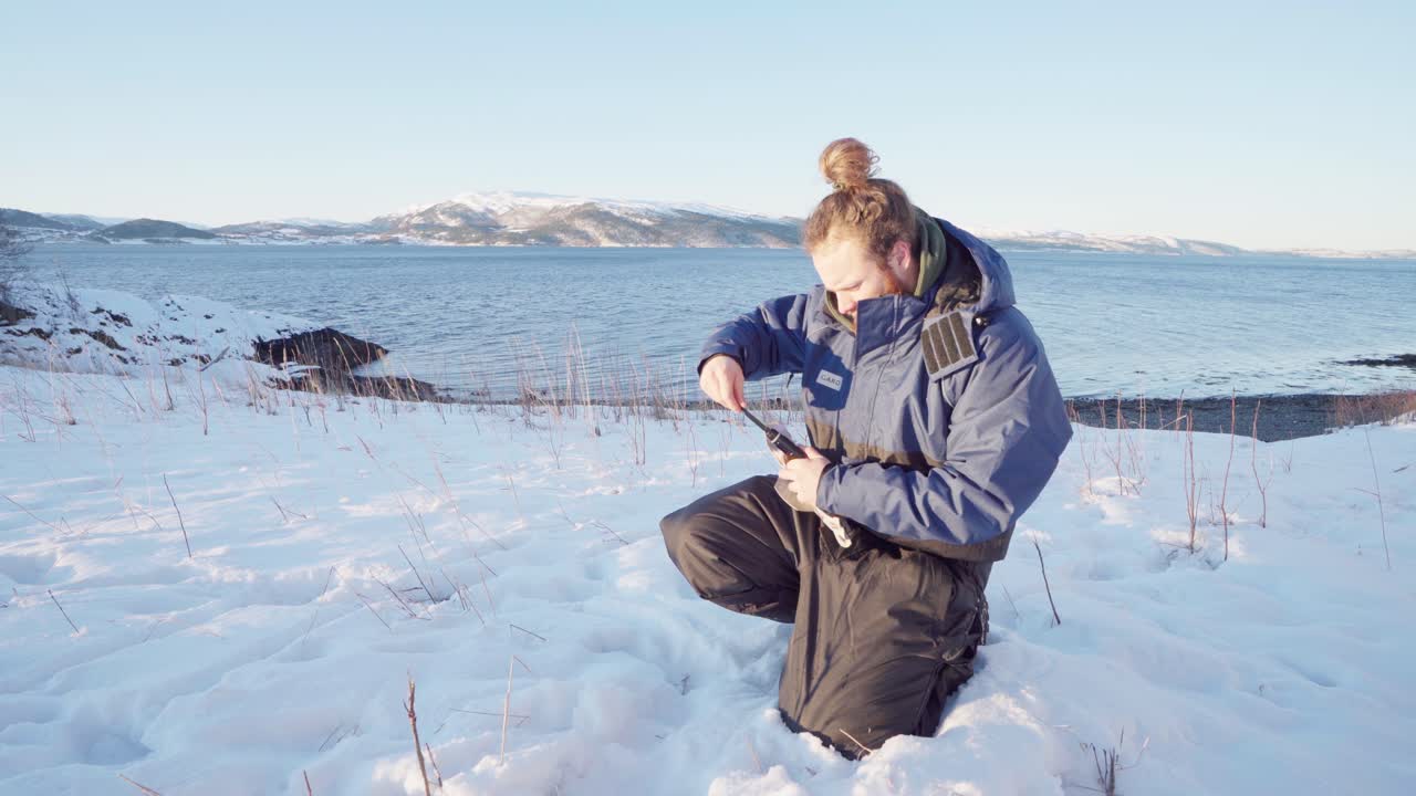 캠핑 미니 삽을 조립하는 눈에 무릎을 꿇고 남자