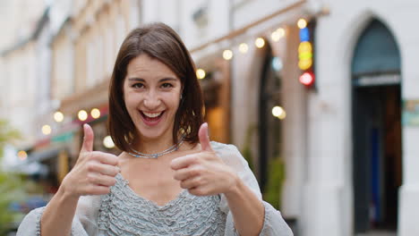 happy woman showing thumbs up, like sign positive something good positive feedback in city street