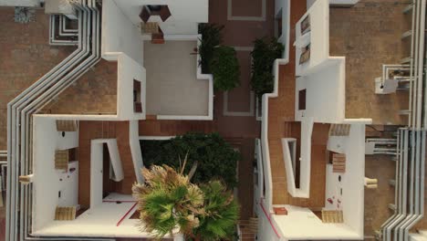 vista aérea de pájaros del complejo de villas hoteleras con palmeras moviéndose en el viento