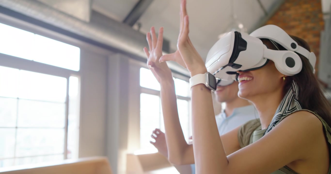 Colleghi diversi che seguono il gesto del presentatore, indossando visori VR bianchi per una demo di prodotto in un loft