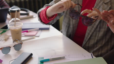 Nahaufnahme-Der-Hände,-Brainstorming-Des-Kreativteams-Mithilfe-Eines-Tablet-Computers,-Entwerfen-Von-Sonnenbrillen,-Betrachten-Von-3D-Designs-Auf-Dem-Bildschirm,-Zusammenarbeit-Bei-Der-Planung-Von-Entwicklungsprojekten,-Austausch-Von-Ideen-Im-Sitzungssaal-Eines-Modernen-Büros