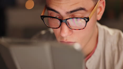 man with glasses using a tablet