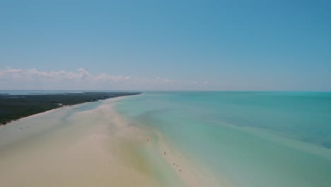 Aerial-view-of-sandy-beach-and-horizon-of-the-Caribbean-Sea,-turquoise-lagoon-of-paradise-island