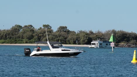 a boat navigates water near buoys