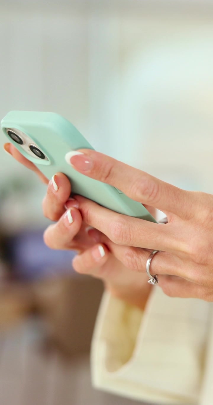 Primo piano di una donna che usa uno smartphone con cover verde menta