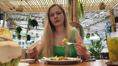 woman enjoying a salad in a tropical restaurant