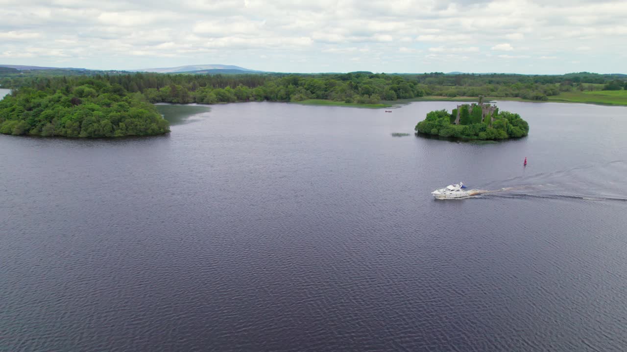 vista aérea de un yate en lough key con el castillo de mcdermott al fondo
