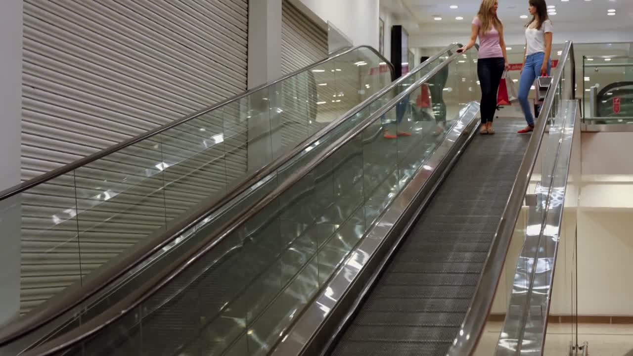 amigos en la escalera mecánica en el centro comercial