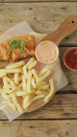 video de pescado y papas fritas en tabla de madera con saltos, con espacio de copia en mesa de madera