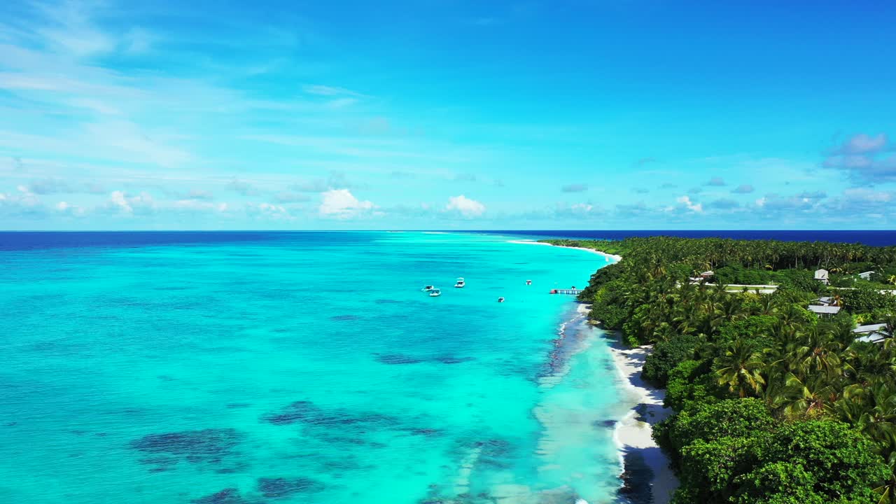 Tranquilla baia di un'isola tropicale con laguna azzurra che bagna dolcemente una spiaggia di sabbia bianca all'ombra di palme sotto un cielo blu brillante nelle Isole Cook