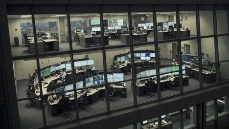 aerial view of a modern office environment showcasing multiple workstations with advanced technology and data screens in a dynamic workplace setting