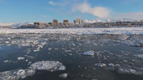 frozen waterway with downtown anchorage skylines in the background, alaska, usa