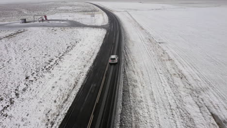 aerial: following a car driving on snowy road