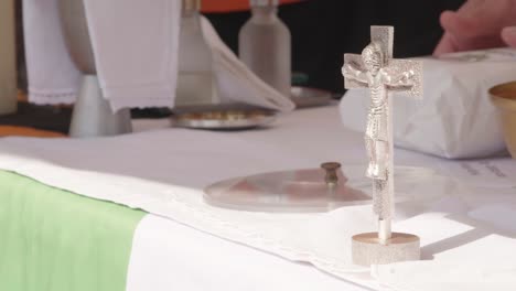 un pequeño crucifijo de plata se encuentra en un altar al aire libre