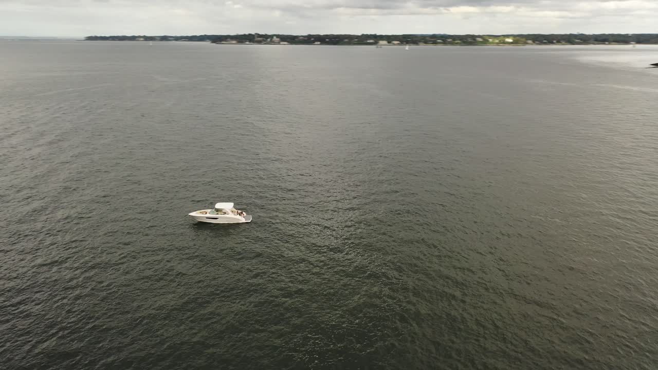 una vista de ángulo bajo de un solo bote blanco anclado en el río este, cerca del puente throgs neck en ny