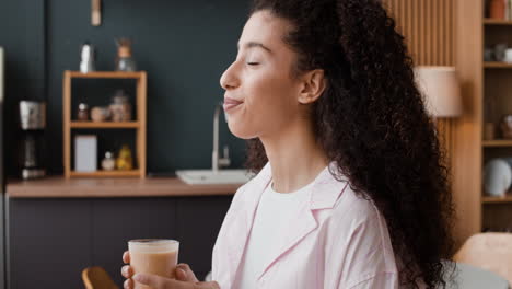 young woman enjoying a drink in a modern kitchen