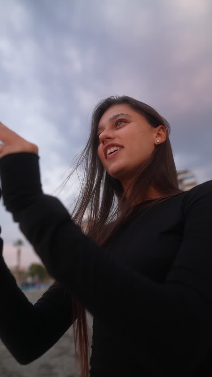 mujer tomando fotos en la playa durante el atardecer