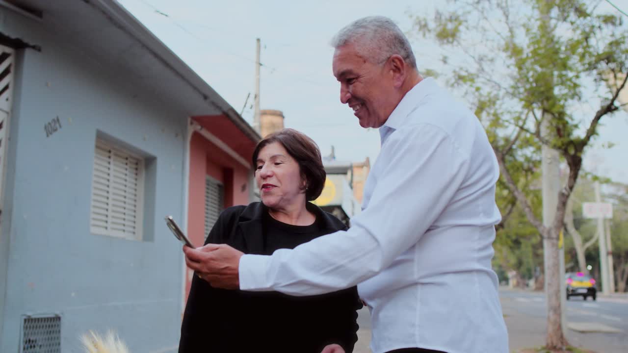 Happy Senior Couple Sharing a Moment with a Smartphone Outdoors