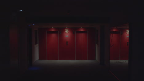 red elevator doors in a dark hallway