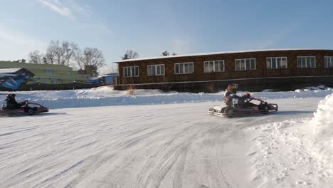 niños en go-kart en una pista nevada