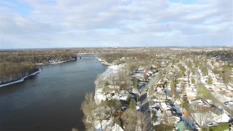 aerial view of a neighborhood in the winter surrounded by water on a sunny day