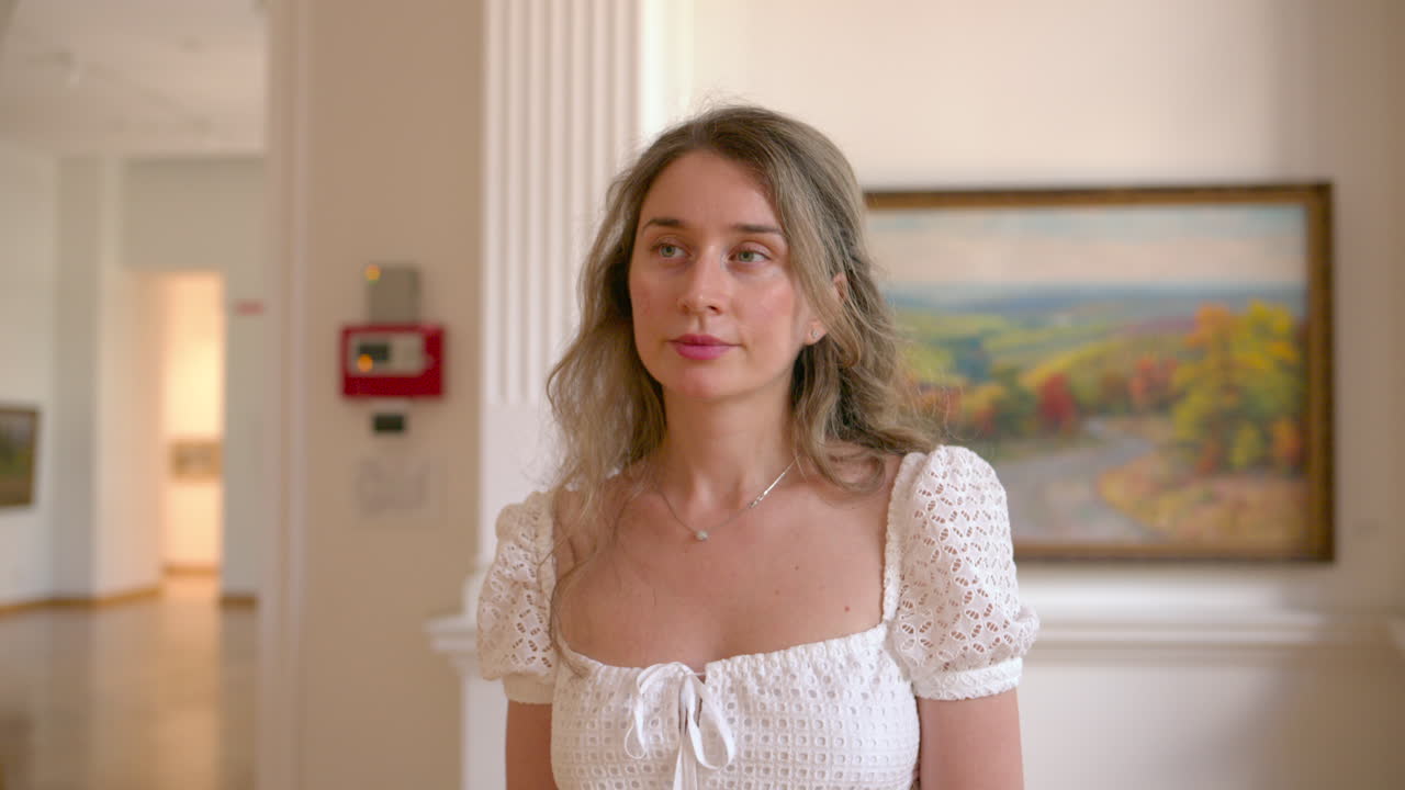 Donna che visita un museo d'arte e ammira i dipinti