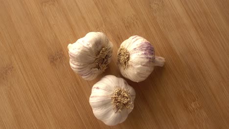 Garlic-in-Rotation-on-Wooden-Background