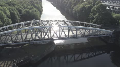 aerial orbit slow right across scenic old vintage steel archway traffic footbridge over manchester ship canal crossing