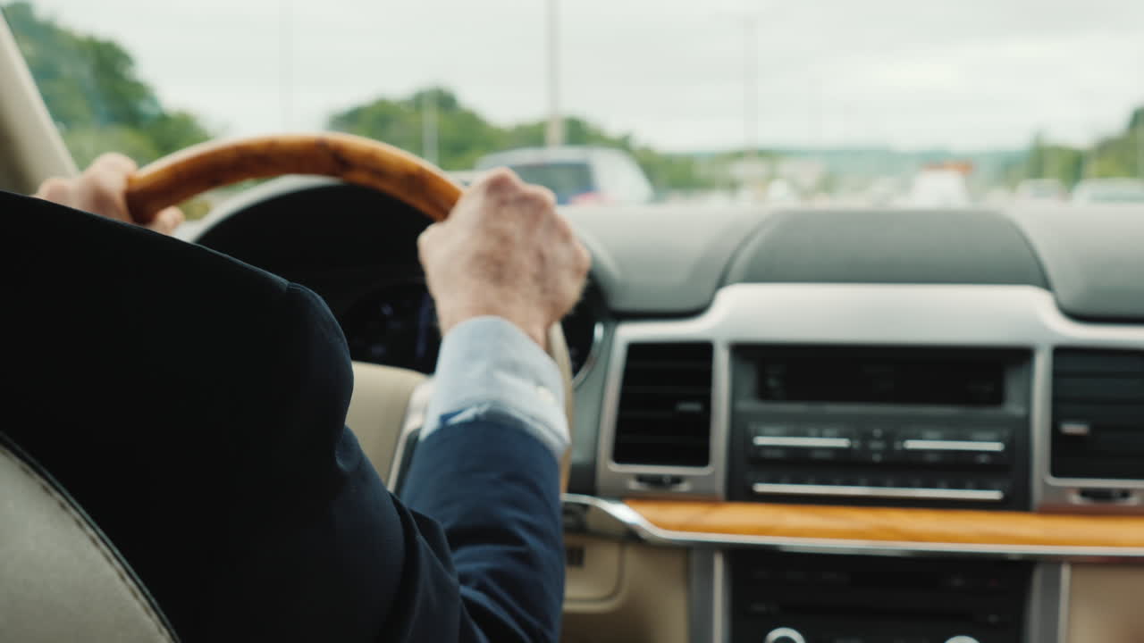 hombre de negocios en un traje de negocios conduciendo un coche el marco muestra las manos de un hombre en el volante