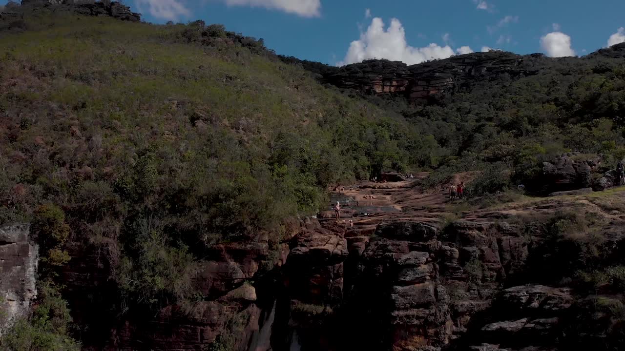 Waterfall in the Andorinhas [Swallows] national park in Ouro Preto, Brazil, revealing the ponds on a rock plateau river bed with stream of a river meandering through a dense vegetation area