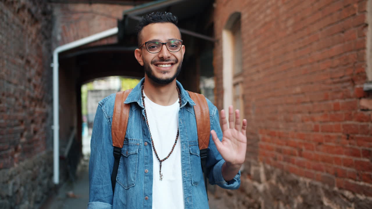 Smiling Man Waving in an Alley
