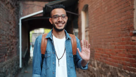 smiling man waving in an alley
