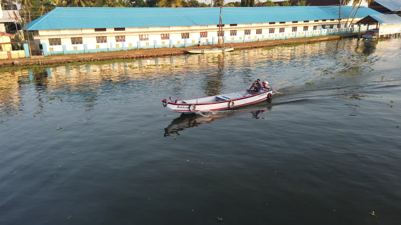 Traditional Fishing Boat Panning to Wide Shot of Keralan Canal Waterway at Sunset at Alappuzha, Kerala, India