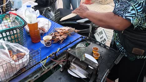 vendor prepares grilled squid at street food stall