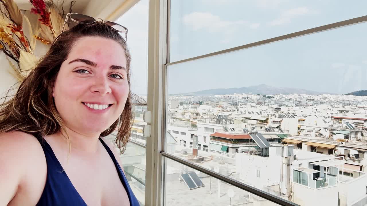 Happy Young Woman Taking a Selfie with a Beautiful Cityscape View from a Rooftop