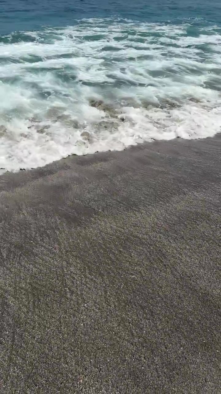 Dolci onde dell'oceano che si infrangono su una spiaggia sabbiosa.