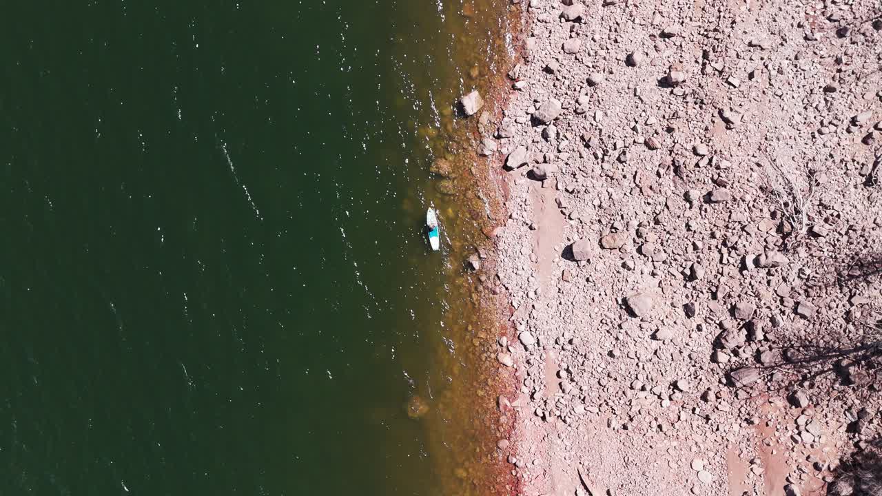 Person paddle boarding on lake next to shore