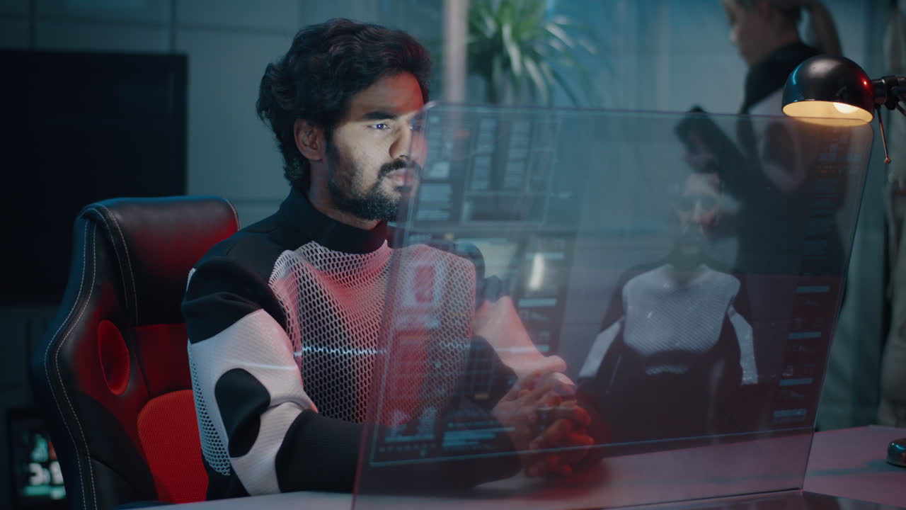 Man working on a futuristic computer with a holographic display