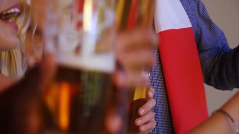 group of friends toasting glasses of beer while watching match 4k