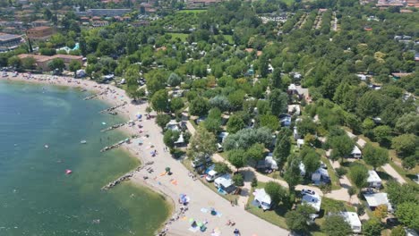 Toma-Aérea-De-La-Playa-En-El-Camping-Baia-Verde-En-La-Orilla-Del-Lago-De-Garda,-Italia