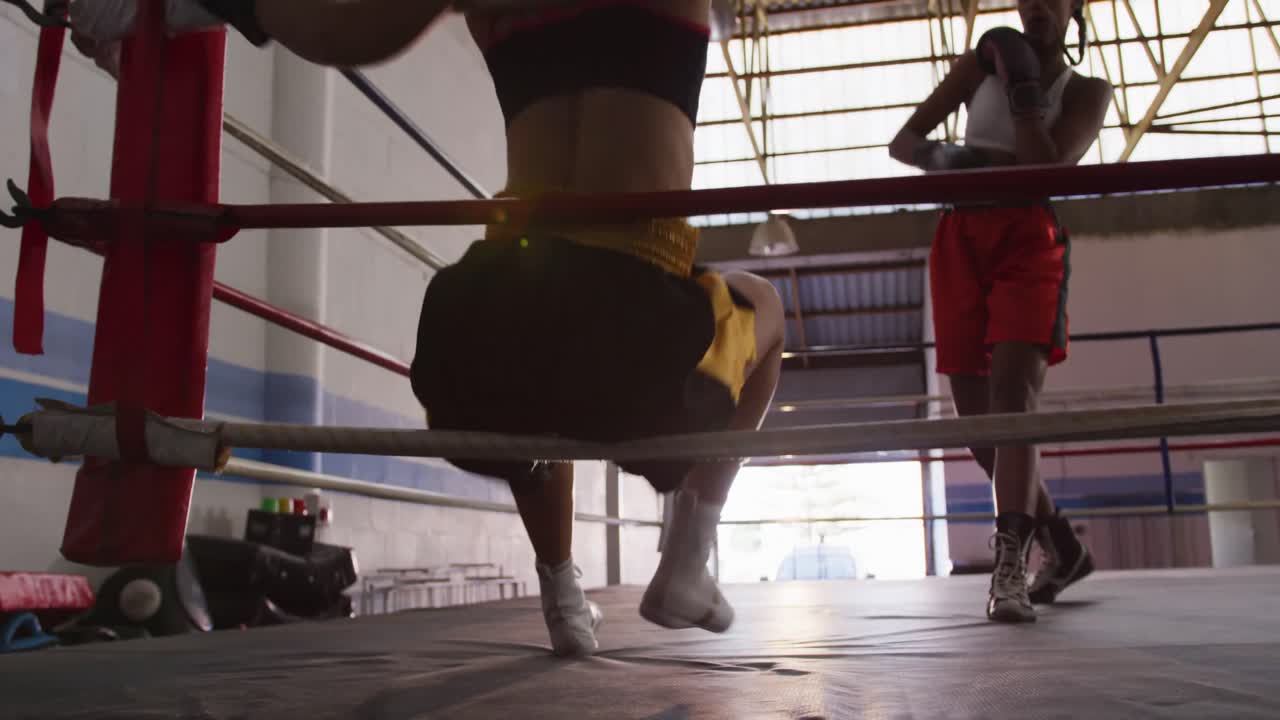 dos mujeres de raza mixta entrenando en el ring de boxeo