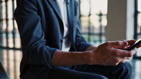 man in suit using smartphone
