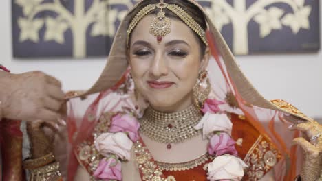 lovely indian bride on her traditional dress and red veil on a hindu wedding ceremony