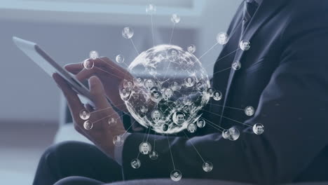 animation of globe of profile icons over caucasian businessman using digital tablet at office